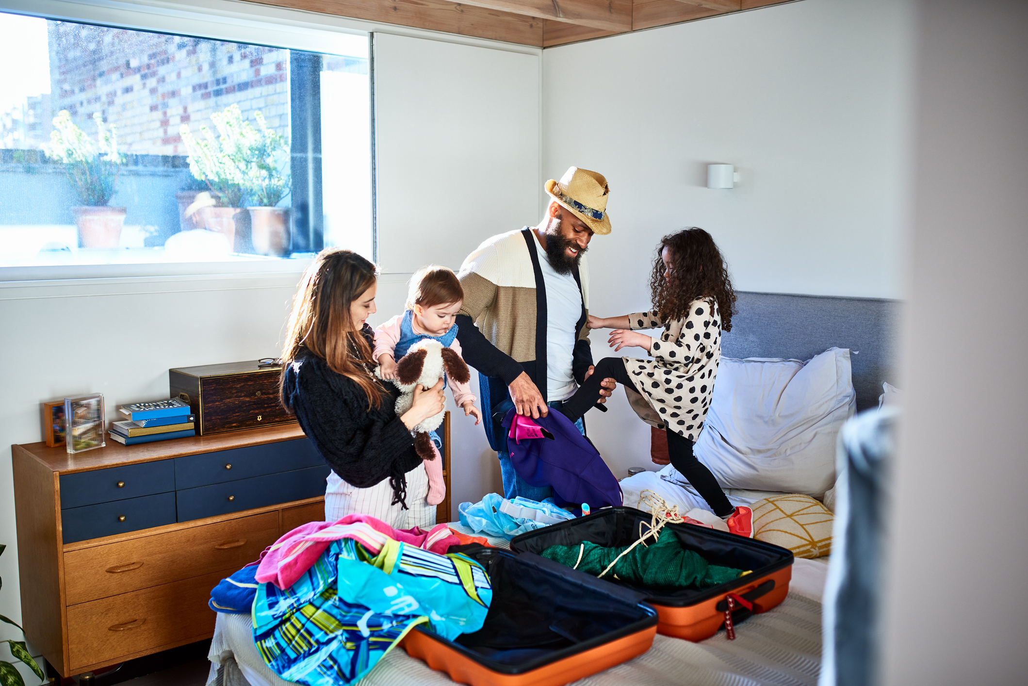 parents-and-two-daughters-packing-suitcase-for-summer-vacation